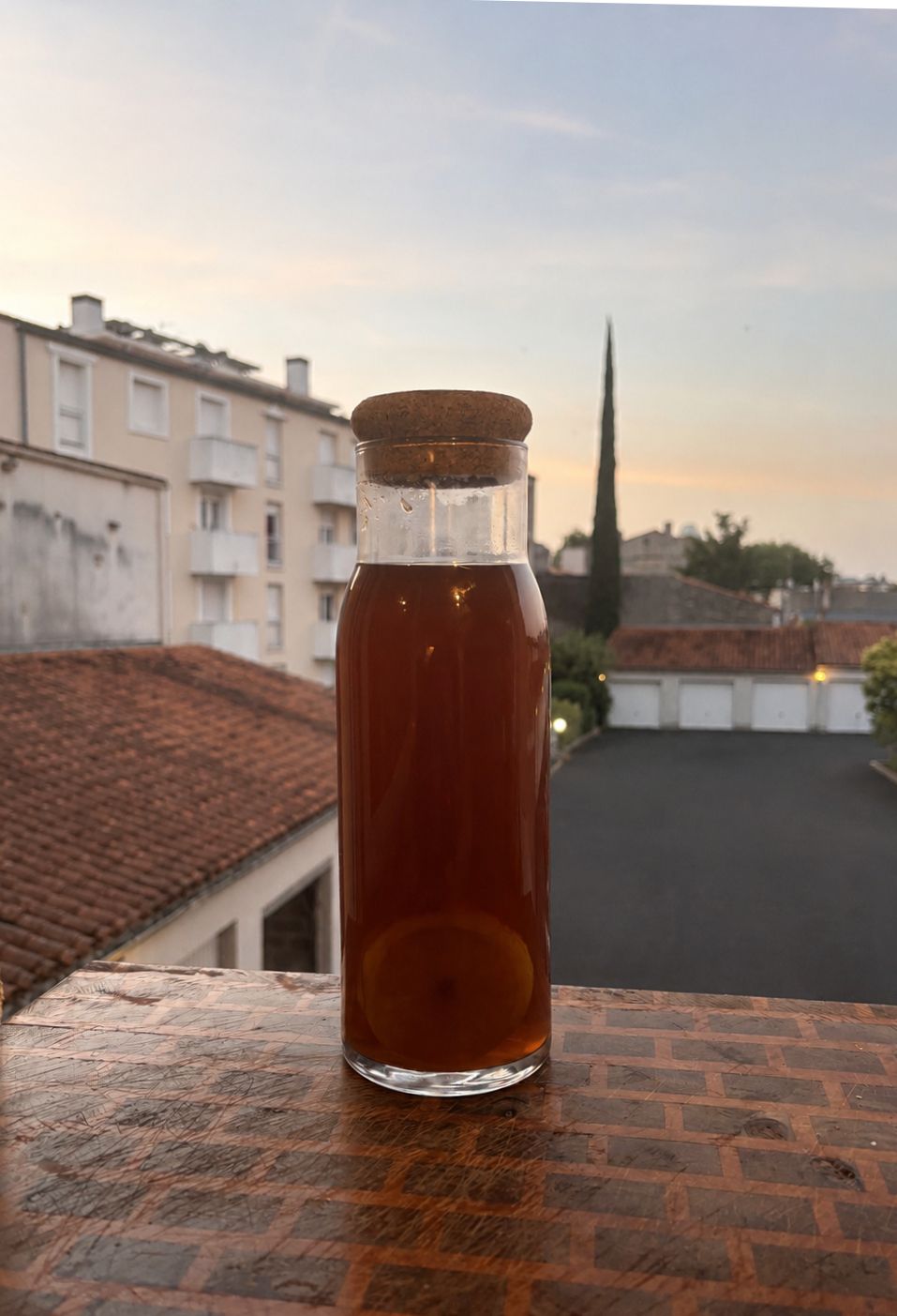 une cruche d'ice tea maison, on y voit des tranches de citron au travers du recipient.